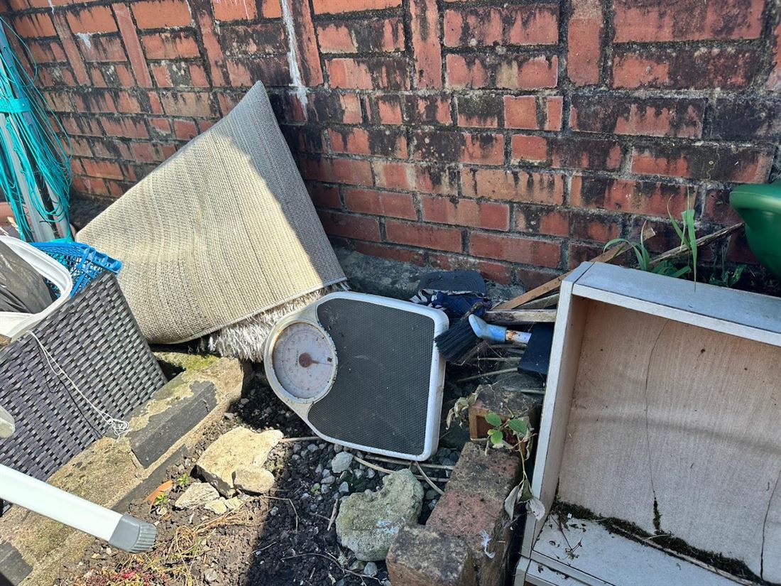 Household clutter and old furniture piled in a back yard